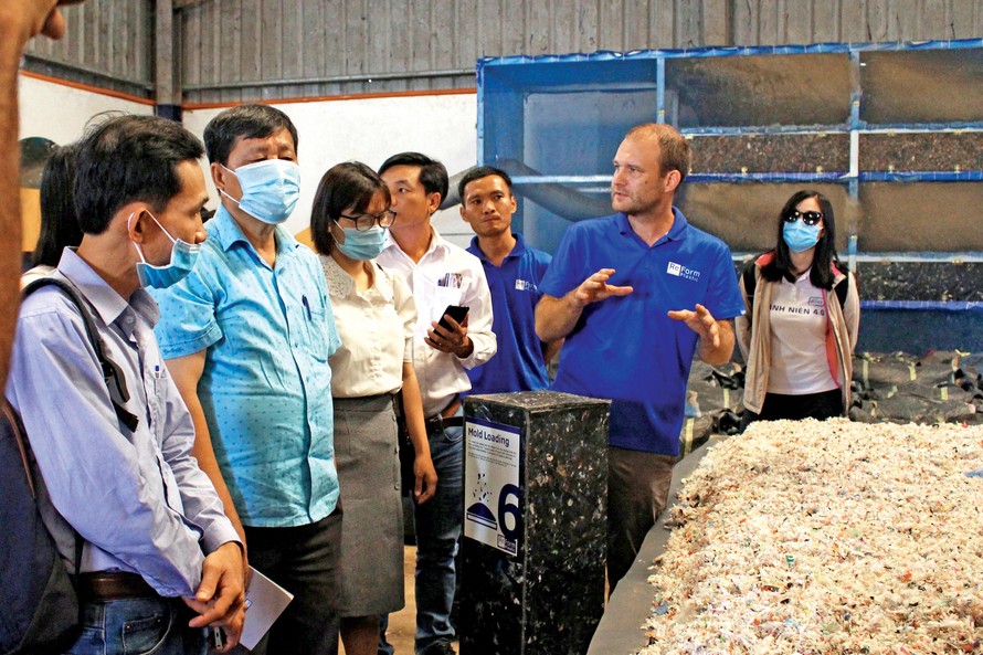 Jan Zellmann, đồng sáng lập Dự án ReForm Plastic giới thiệu về quy trình “tạo hình” rác cho khách tham quan nhà máy. Ảnh: Giang Thanh