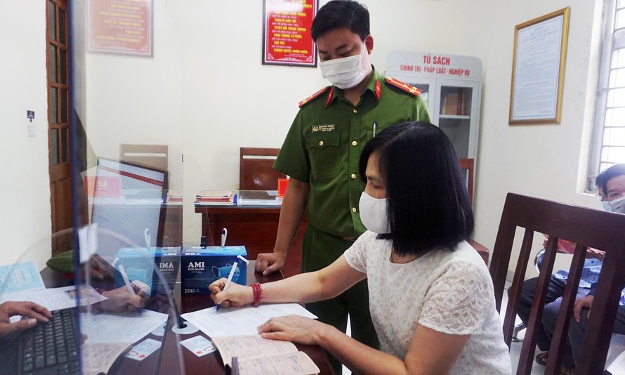 Cán bộ công an hướng dẫn người dân làm thủ tục thay đổi thông tin về cư trú vào ngày 1/7 tại Hà Nội. Ảnh: Thanh Hà