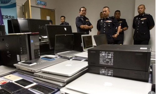 Những chiếc điện thoại, laptop bị tịch thu trong vụ truy quét mới nhất của cảnh sát Malaysia. Ảnh: AP