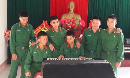 Binh nhất Hồ Văn Long (thứ 3, phải sang) đang hướng dẫn đồng đội chơi đàn Organ. Ảnh: T.H
