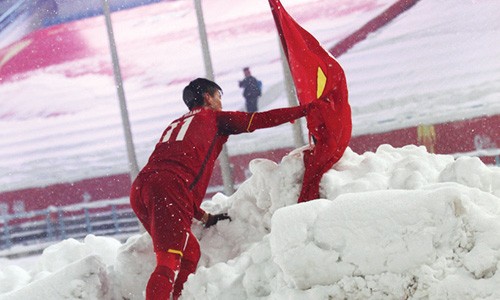 Khoảnh khắc Duy Mạnh cầm cờ leo lên đụn tuyết cao, cắm lá cờ trên đỉnh đụn tuyết và cúi đầu chào. Ảnh: Hoàng Linh TTXVN