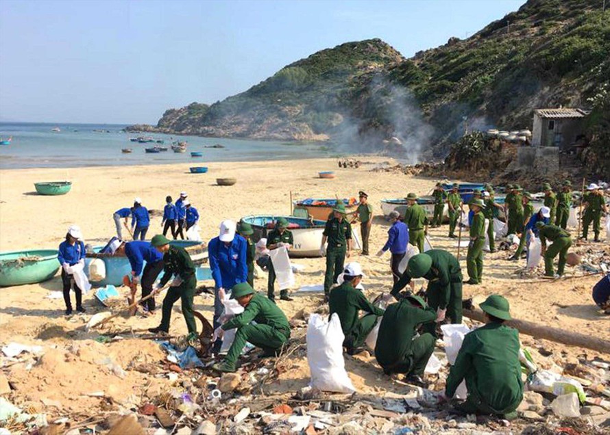ĐVTN và các cán bộ, chiến sĩ BĐBP Bình Định tham gia vệ sinh môi trường biển. Ảnh: CTV