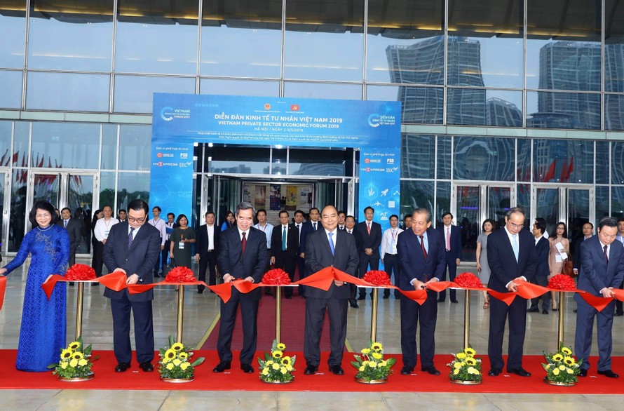 Thủ tướng Nguyễn Xuân Phúc và các đồng chí Lãnh đạo Đảng, Nhà nước cắt băng khai mạc triển lãm Thành tựu kinh tế tư nhân. Ảnh: TTXVN 