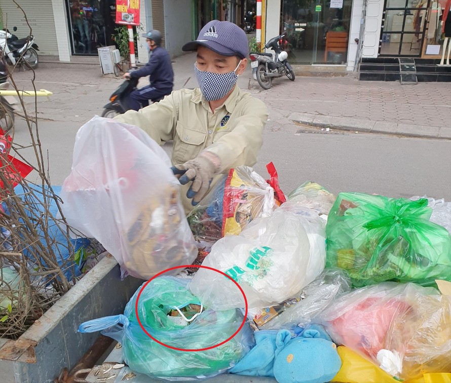 Công nhân môi trường tác nghiệp tại một điểm thu gom rác trên đường Khương Trung. Ảnh: Long Vân