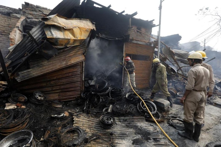 Lính cứu hỏa đang dập đám cháy tại một cửa hàng buôn bán lốp ô tô. Ảnh: Reuters