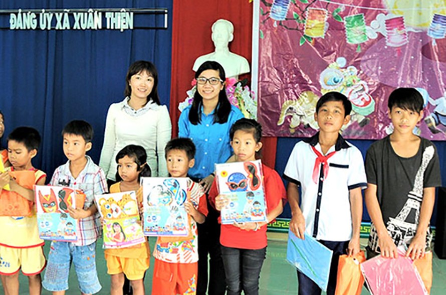 Trần Thị Thanh Thanh, Chủ nhiệm CLB Kĩ năng sống huyện Trảng Bom, tỉnh Đồng Nai (hàng sau bên phải) tặng quà trung thu cho các em nhỏ