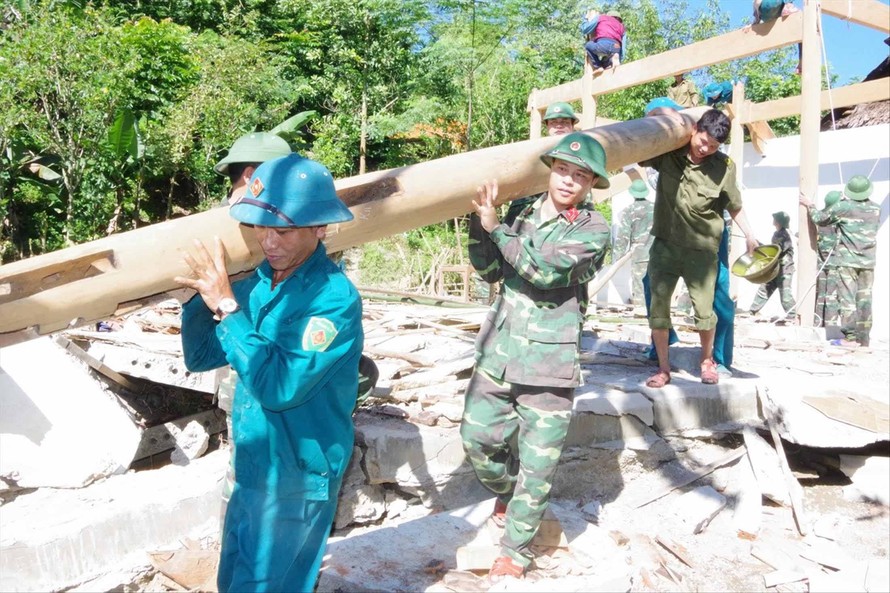 Cán bộ, chiến sỹ Ban CHQS huyện Tương Dương giúp gia đình ông Lô Văn Tiến ở bản Vẽ di dời nhà bị sập do mưa lũ. Ảnh: P.Q