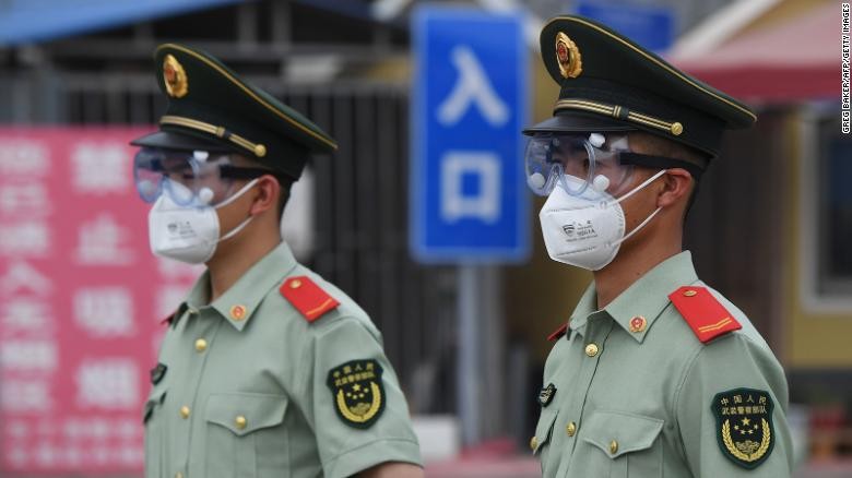 Cảnh sát bán quân sự đeo khẩu trang, kính bảo hộ khi đứng gác tại cổng chợ đầu mối Tân Phát Địa ở Bắc Kinh hôm 13/6. Ảnh: Getty Images 