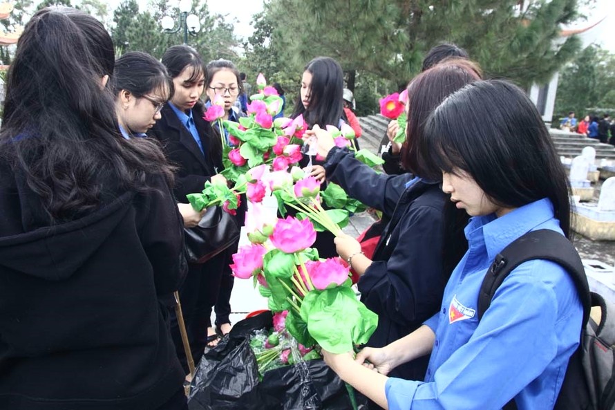 Các bạn đoàn viên, thanh niên nâng niu những đóa hoa trước khi dâng lên mộ liệt sĩ. Ảnh: THANH LỘC