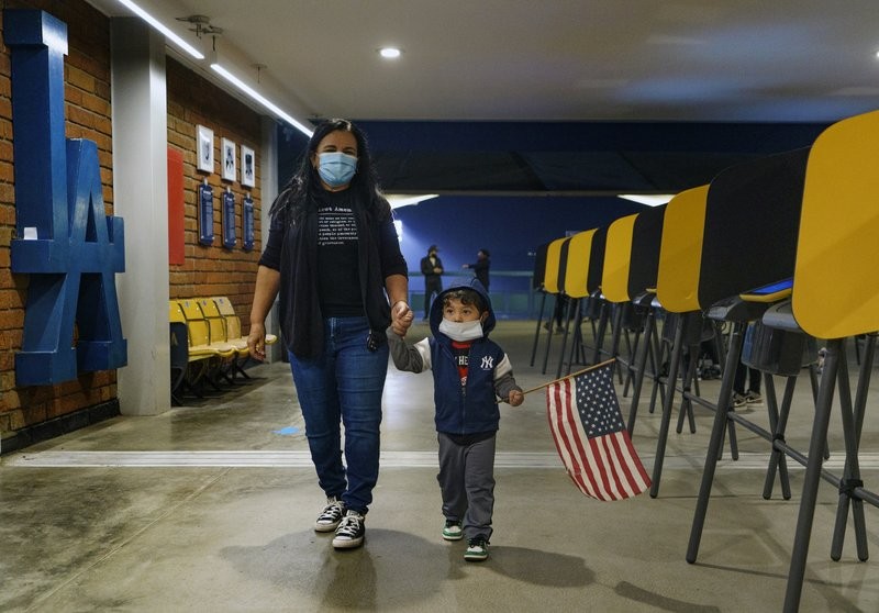 Một phụ nữ Mỹ dắt theo con trai đi bỏ phiếu ở thành phố Los Angeles, bang California. Ảnh: AP 