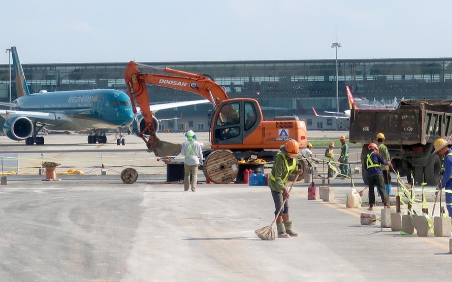 Công nhân thi công sân bay Nội Bài khi hoạt động khai thác bay vẫn diễn ra