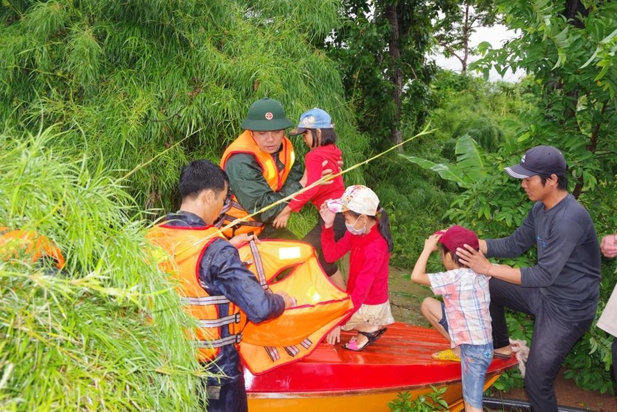 Chiến sĩ Đoàn Kinh tế - Quốc phòng 737 dùng ca nô đưa trẻ em ra khỏi vùng ngập lụt.