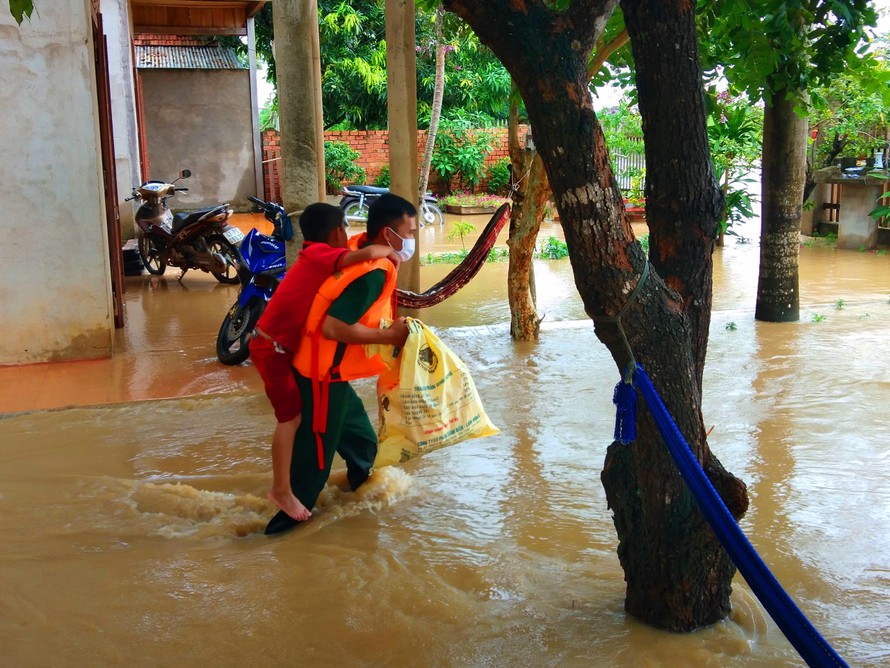 Bộ đội giúp dân di dời ra khỏi nhà bị ngập lụt. Ảnh: N. Lân
