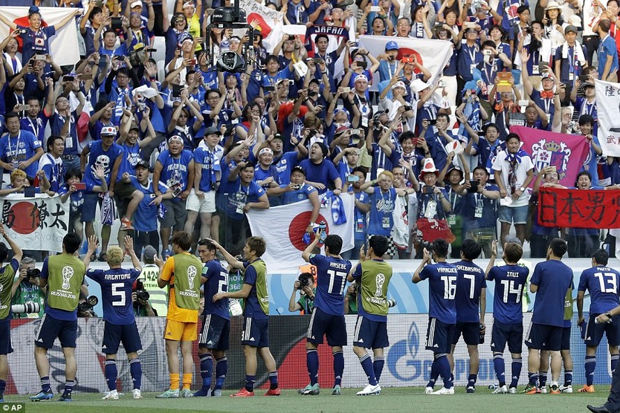 Các cầu thủ Nhật Bản và CĐV ăn mừng thành tích giành vé vào vòng 1/8.