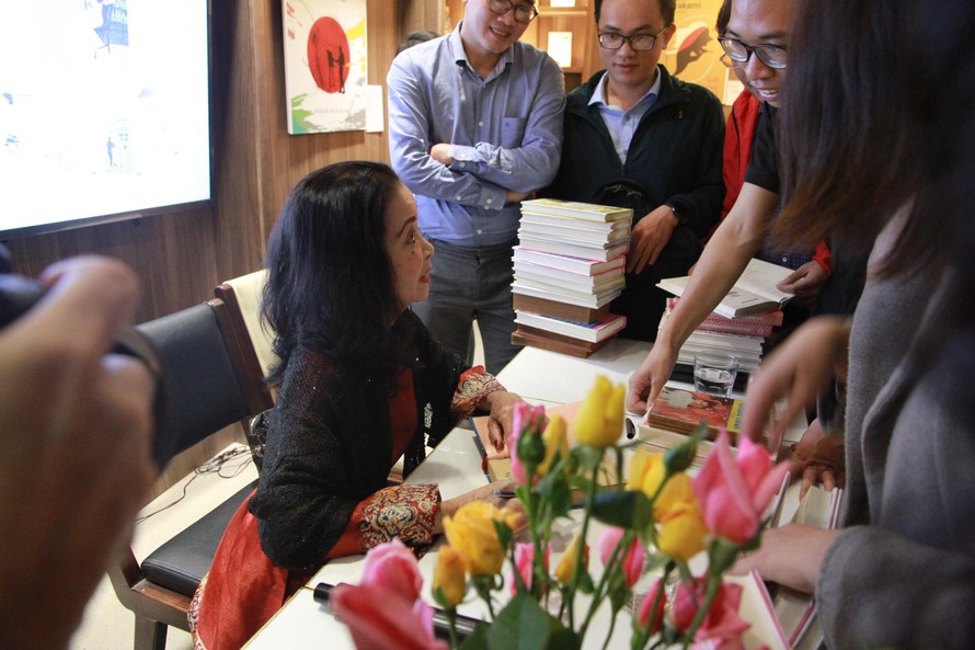 Nhà văn Nguyễn Thị Hoàng ký tặng độc giả trẻ lên những bản sách cả mới và cũ. Ảnh: MẠNH HÀ