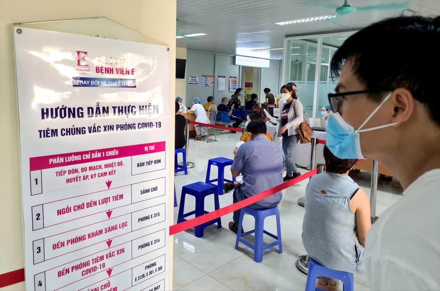 Người dân đợi tới lượt tiêm vắc-xin COVID-19 tại Bệnh viện E - Hà Nội