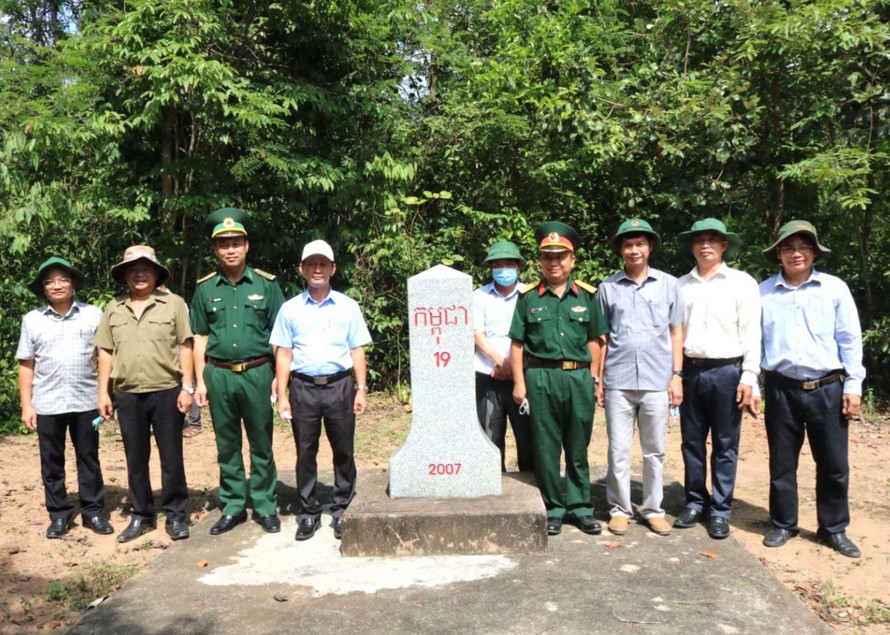 Ông Dương Văn Trang (mũ trắng) chụp ảnh lưu niệm cùng cán bộ, chiến sĩ ở cột mốc biên giới