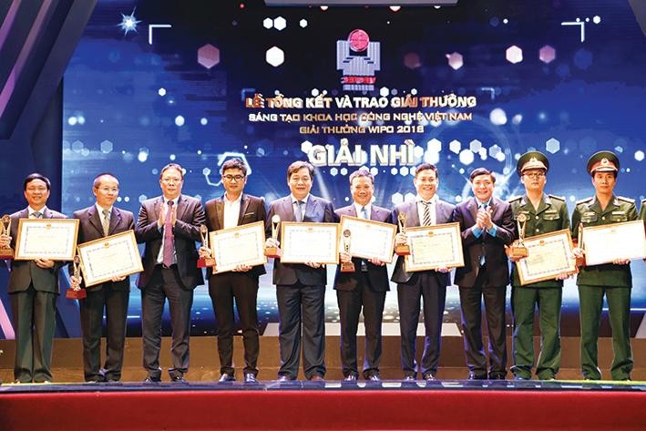 NGND.PGS.TS Trần Đức Quý, Hiệu trưởng nhà trường và ông Hoàng Anh, Giám đốc trung tâm Đảm bảo chất lượng (đứng giữa) nhận giải thưởng Sáng tạo Khoa học Công nghệ Việt Nam (Vifotec) năm 2018. 