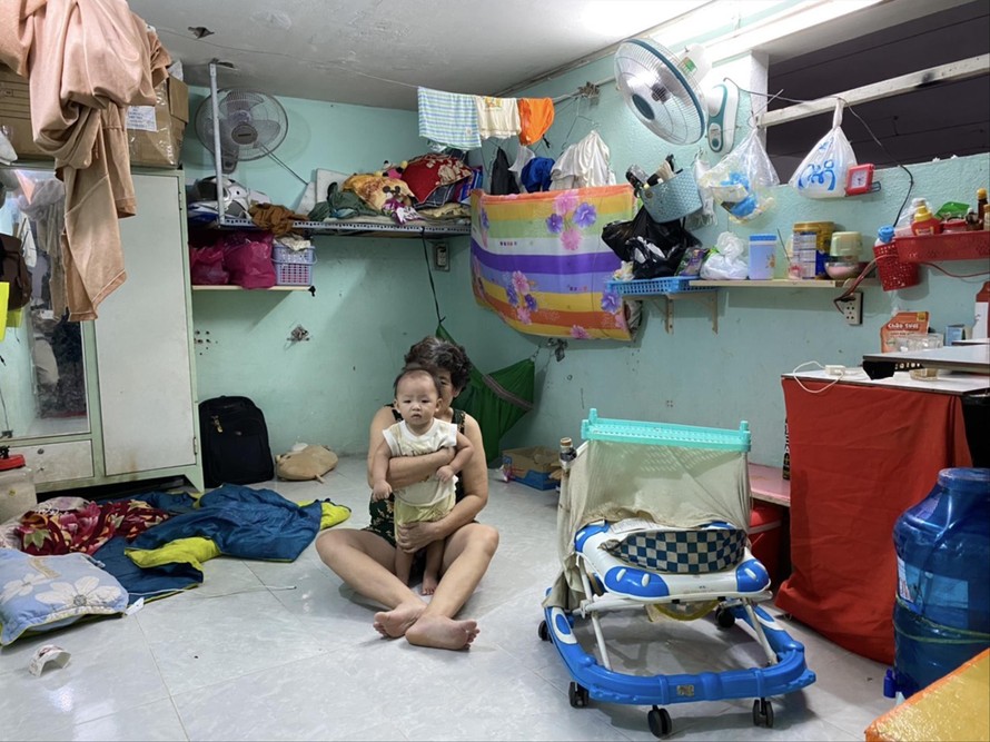 Mẹ vợ và con anh Nguyễn Văn Tuấn trong căn phòng trọ ở quận 11. Ảnh: DUY QUANG 