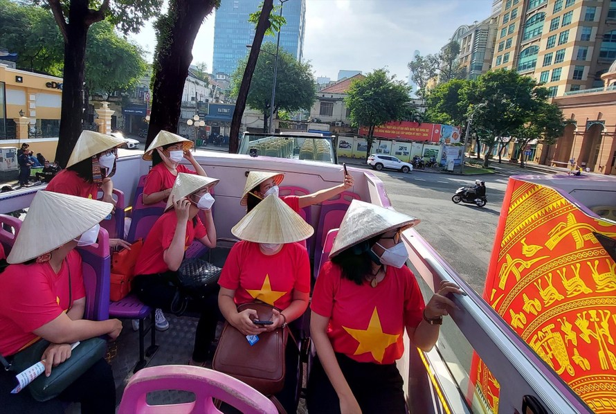 Du khách ngắm nhìn đường phố Sài Gòn từ xe buýt 2 tầng. Ảnh: Chang Chang