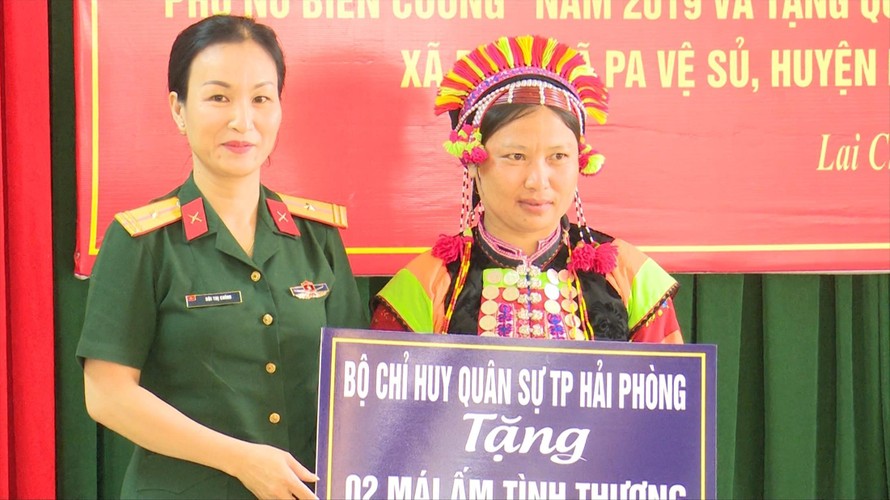 Thiếu tá Bùi Thị Chính (Phòng Chính trị Bộ CHQS thành phố Hải Phòng) trao tiền hỗ trợ phụ nữ có hoàn cảnh khó khăn ở 2 xã Pa Ủ và Pa Vệ Sủ thuộc huyện Mường Tè, tỉnh Lai Châu 
