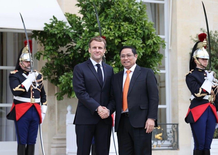 Tổng thống Pháp Emmanuel Macron tiếp đón thân tình Thủ tướng Phạm Minh Chính. Ảnh: TTXVN