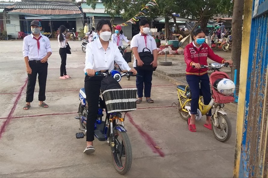 Học sinh khối lớp 9 và 12 ở huyện Tân Phú Đông, tỉnh Tiền Giang trở lại trường Ảnh: NHẬT HUY