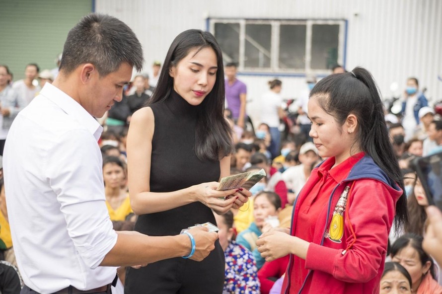 Vợ chồng ca sỹ Thuỷ Tiên trao tiền hỗ trợ cho người dân trong một lần từ thiện 