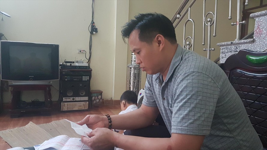 Anh Trần Văn Miện, ở thôn Giang Liễu, xã Phương Liễu, Quế Võ Bắc Ninh đang kiểm tra hóa đơn tiền điện. Ảnh: Đức Anh