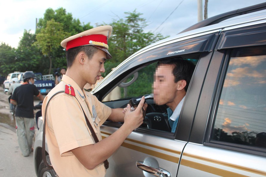 Cảnh sát giao thông kiểm tra nồng độ cồn của một lái xe Ảnh: Hồng Vĩnh 