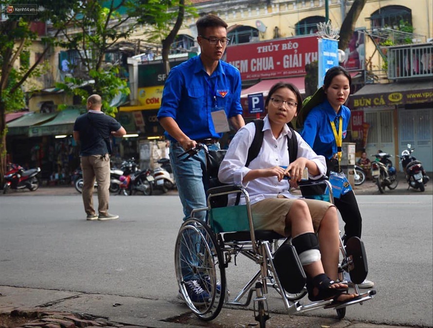 Các tình nguyện viên hỗ trợ thí sinh Nguyễn Thị Thúy Hà bị tai nạn giao thông vào điểm thi trường THPT Việt Đức Ảnh: CTV