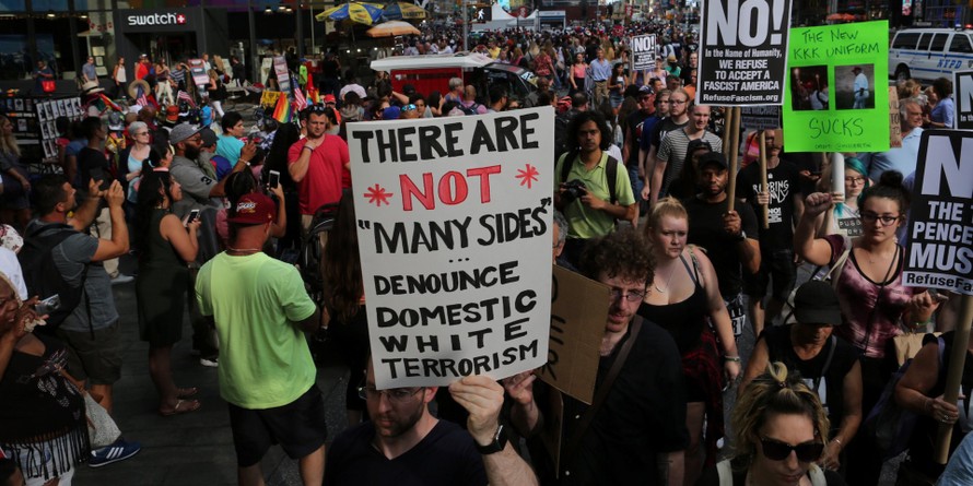  Một người giương biểu ngữ phản đối bạo lực tại quảng trường Times Square, New York sau vụ xả súng ở Charlottesville, Virginia năm 2017 Ảnh: Business Insider/Reuters