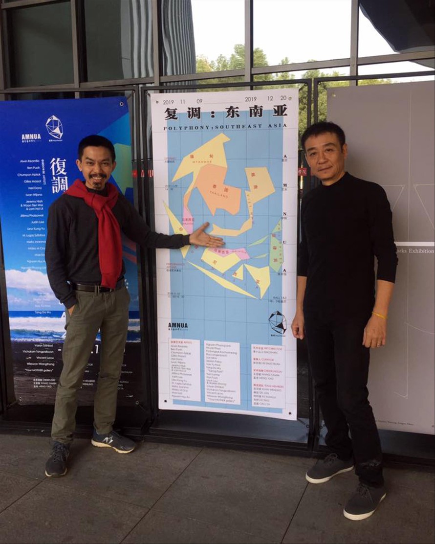 Nghệ sĩ Trần Lương (bên phải) nói với nhà sưu tập Nguyễn Đức Thành (trái) trước giờ khai mạc Polyphony: Southeast Asia tại Trung Quốc: “Tấm poster này chính là một tác phẩm của chúng ta trong triển lãm này!” Ảnh: NVCC