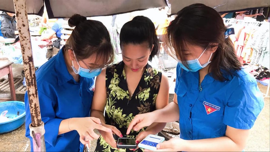 Thanh niên tình nguyện Hà Giang đến các khu chợ hướng dẫn bà con cài đặt, sử dụng ứng dụng Bluezone Ảnh: PV