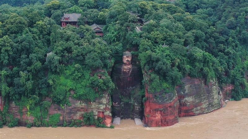 Nước lũ ngập tới chân tượng Lạc Sơn Ðại Phật sau những trận mưa lớn. Ảnh: China Daily/Reuters