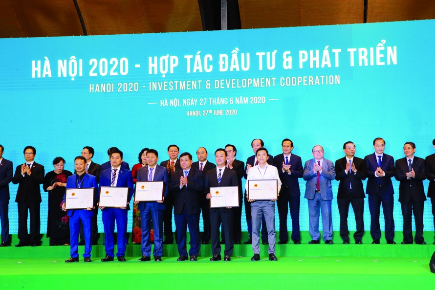 Ông Nguyễn Việt Hùng - Bí thư Ðảng ủy, Chủ tịch HÐTV HUD (Hàng đầu, thứ hai, từ phải sang) nhận Quyết định chủ trương đầu tư Dự án NƠXH HUD Vân Canh tại Hội nghị Hợp tác đầu tư & phát triển do TP Hà Nội tổ chức vào tháng 6/2020 ​