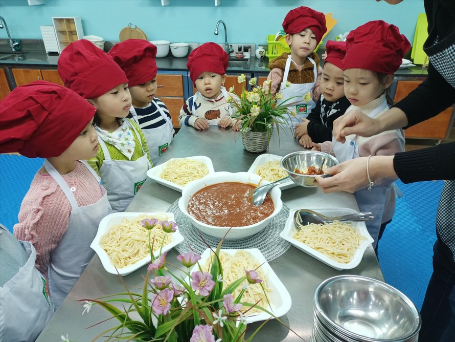 Trẻ mẫu giáo Trường mầm non Thực hành Linh Ðàm (Hà Nội) trong một giờ học làm món mỳ Ý 