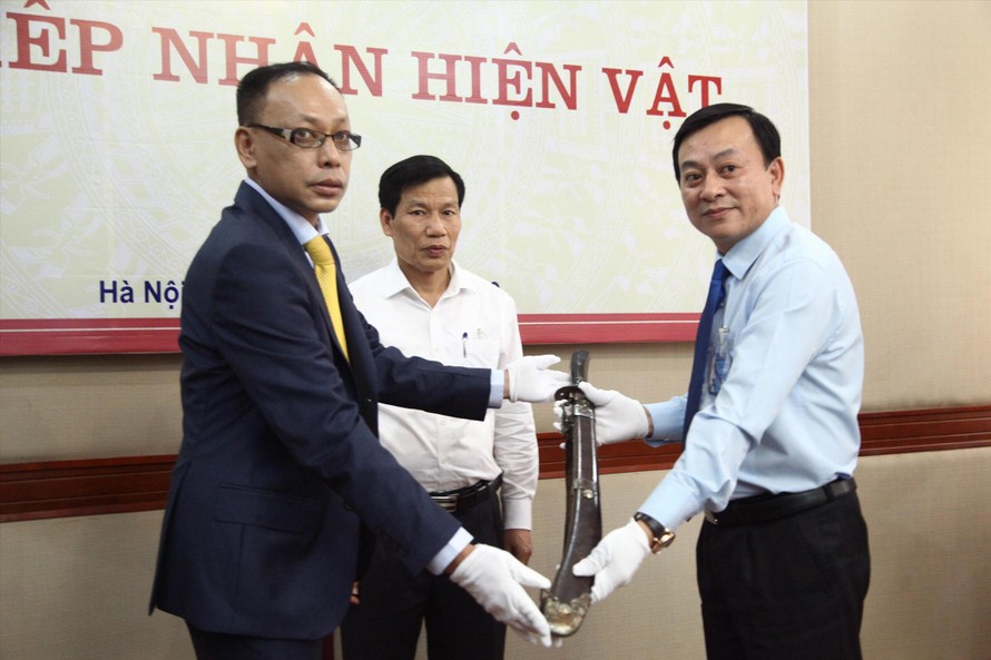 Bộ trưởng VHTTDL chứng kiến ông Vương Quỳnh Xuân (trái) trao hiện vật quý cho Bảo tàng Hồ Chí Minh. Ảnh: SƠN TUẤN
