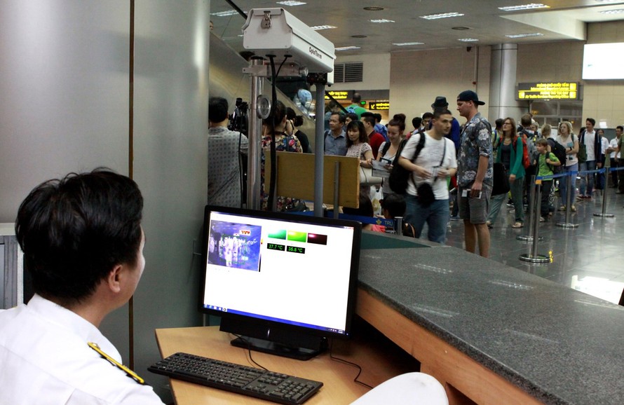 Kiểm tra thân nhiệt của hành khách tại sân bay Quốc tế Tân Sơn Nhất. Ảnh: Hồng Vĩnh