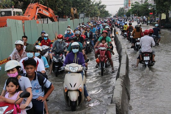 Người dân khổ sở qua đường Huỳnh Tấn Phát vì ngập dù đang được nâng cao độ, thay cống hộp. 