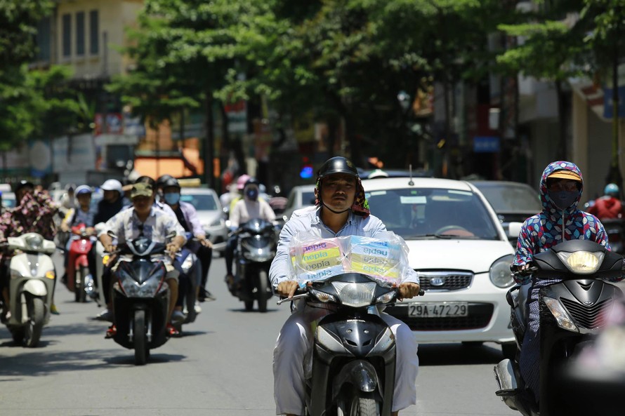 Người đi đường đều phải che kín từ đầu đến chân trong những ngày nắng nóng tại Hà Nội ảnh: Như Ý 