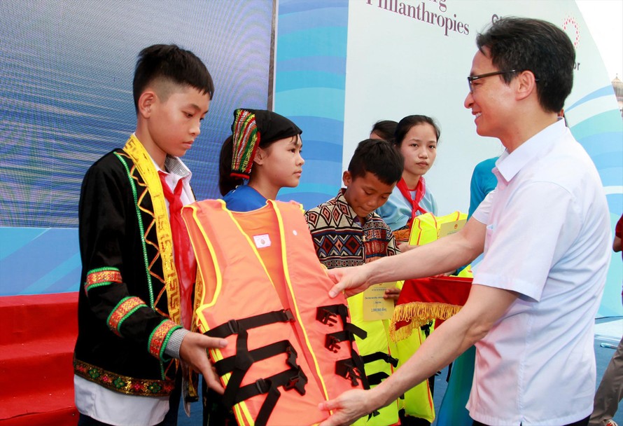 Phó Thủ tướng Vũ Đức Đam - Chủ tịch Ủy ban Quốc gia về trẻ em tặng áo phao cho học sinh dân tộc thiểu số. Ảnh: Mạnh Dũng 