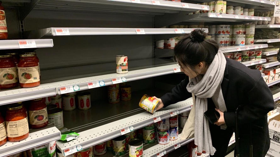 Một khách hàng đang chọn mua hộp sốt cà chua tại cửa hàng tạp hóa Whole Food ở thành phố New York. Ảnh: Alex Fang