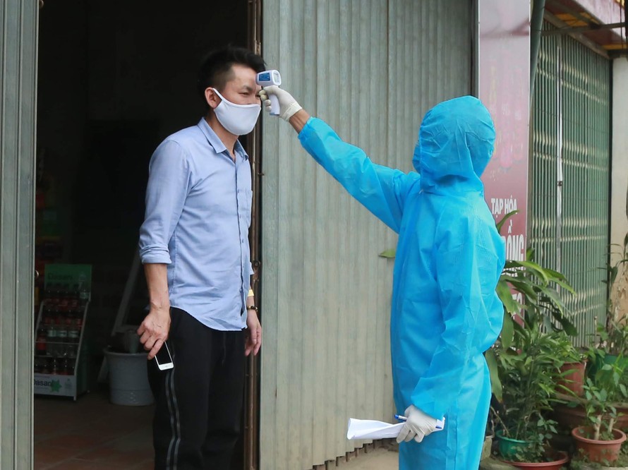 Bác sĩ đến tận nhà dân đo nhiệt độ và lấy thông tin hằng ngày tại xã Sơn Lôi, huyện Mê Linh, Hà Nội. Ảnh: Nhật Minh
