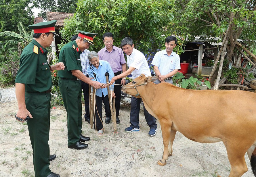 Trung tướng Nguyễn Đức Soát, Chủ tịch Hội Hỗ trợ khắc phục hậu quả bom mìn Việt Nam, tặng bò cho nạn nhân bom mìn tại huyện Bố Trạch, tỉnh Quảng Bình. Ảnh: L.A 