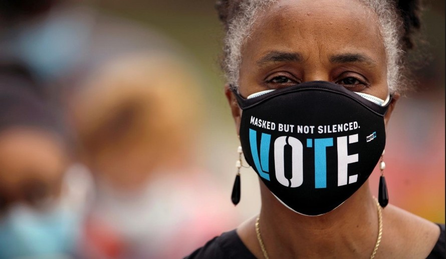 Một cử tri da màu Mỹ đeo khẩu trang có dòng chữ: “Che mặt nhưng không im lặng. Bầu cử” Ảnh: Getty 