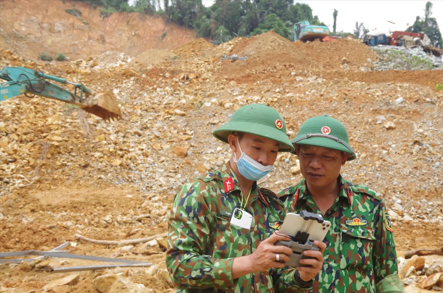 Trung tá Phan Thắng, Tham mưu trưởng Bộ CHQS tỉnh Thừa Thiên - Huế (phải), cập nhật thông tin để chỉ huy đơn vị tìm kiếm người mất tích ở thủy điện Rào Trăng 3. ẢNH: PV 