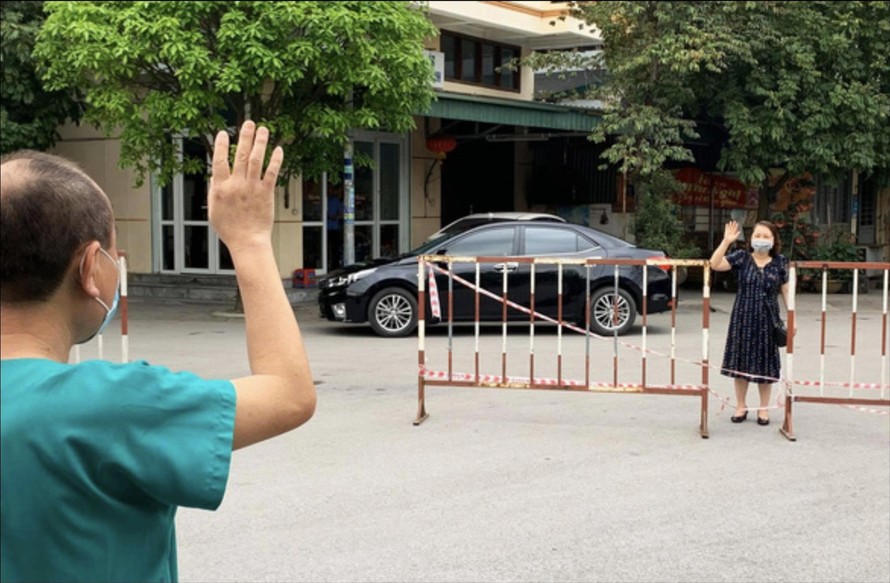 Bác sĩ Nguyễn Quốc Hùng và vợ chỉ có thể gặp, nói chuyện từ xa sau hàng rào cách ly tại Bệnh viện dã chiến số 2 tỉnh Quảng Ninh