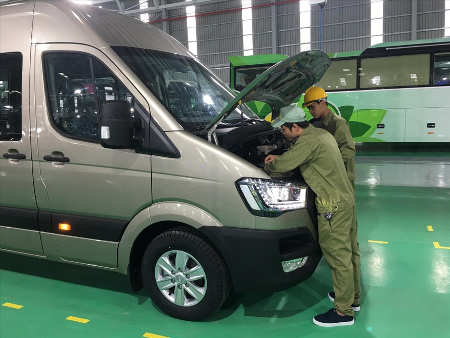 Các công nhân Thaco đang kiểm tra kỹ thuật xe  buýt nhỏ Ảnh: Tuấn Nguyễn 