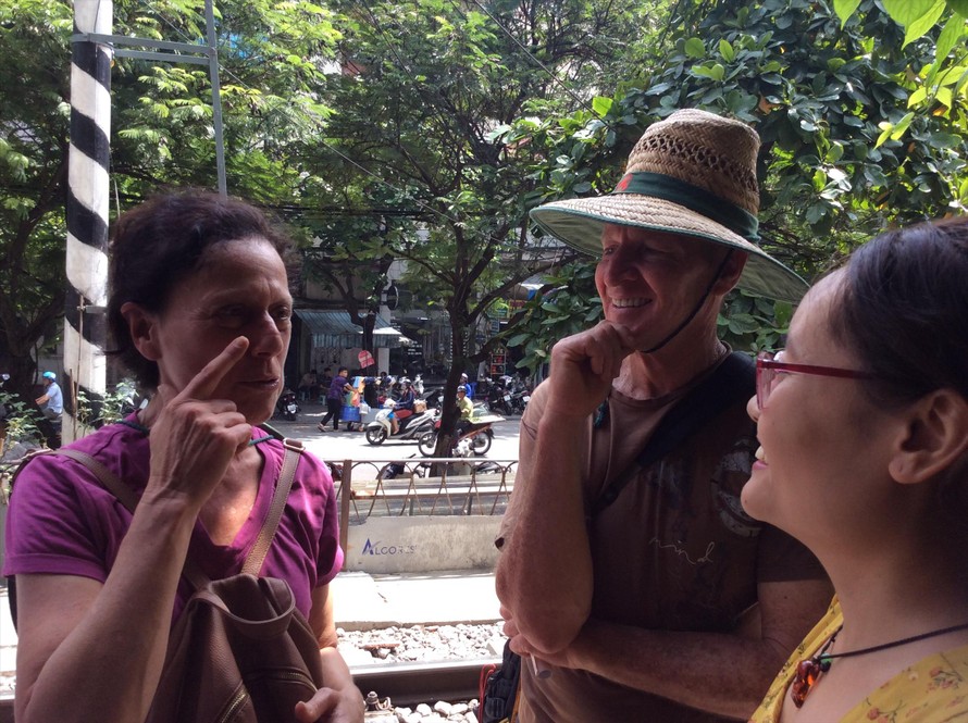 Vợ chồng nhà báo Úc Laura Watkins trò chuyện với dân xóm đường tàu sáng 10/10. Họ là du khách hiếm hoi vào được đây.